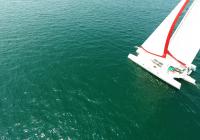 blanc trimaran à bleu-vert navigue sur la mer